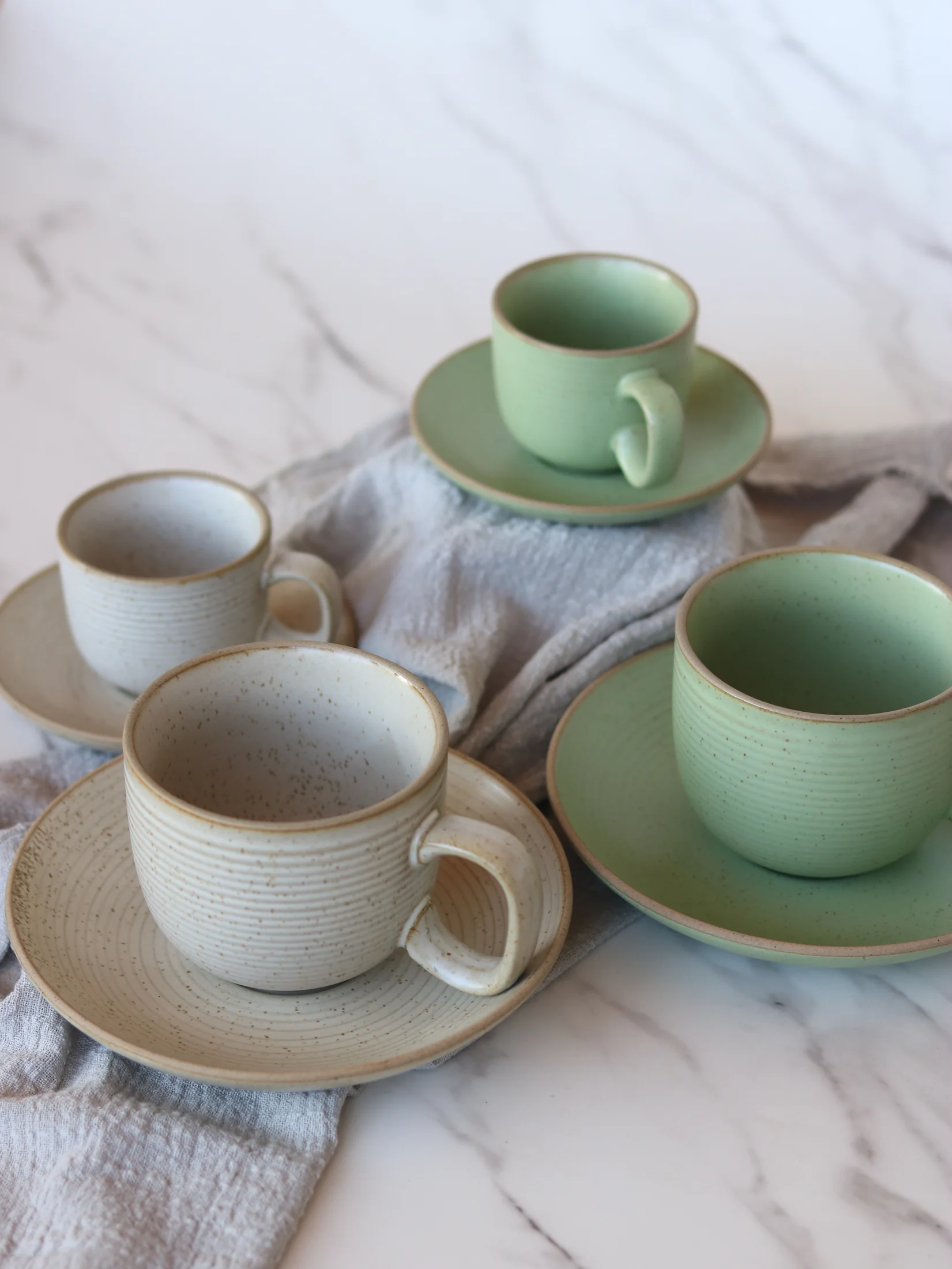 Sage green and cream tableware with plates and cups - product photograph